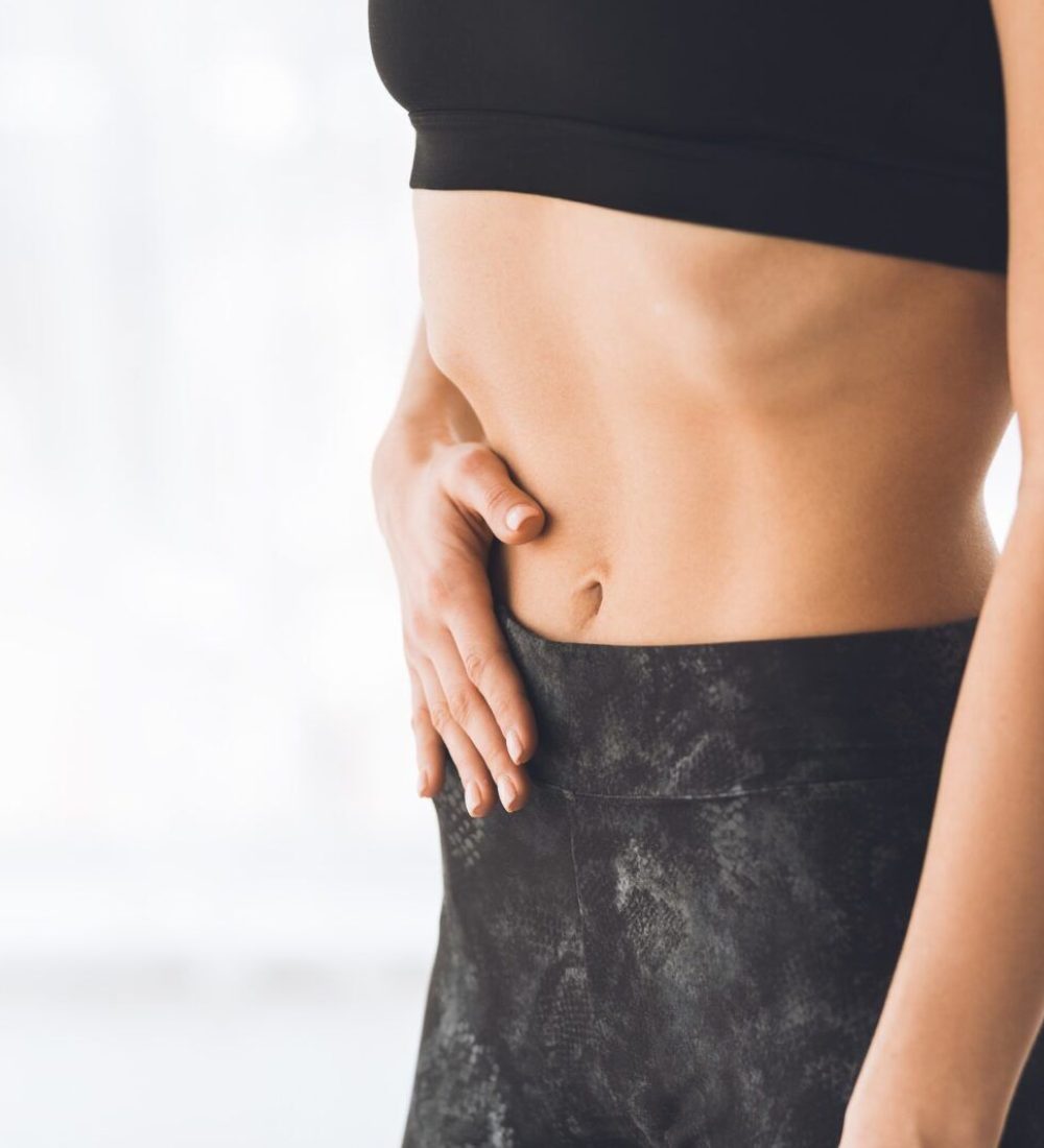 Young woman making exercise on belly vacuum